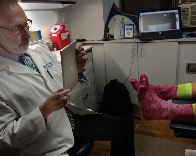 Podiatrist using iPad to capture foot photos and enter digital prescription