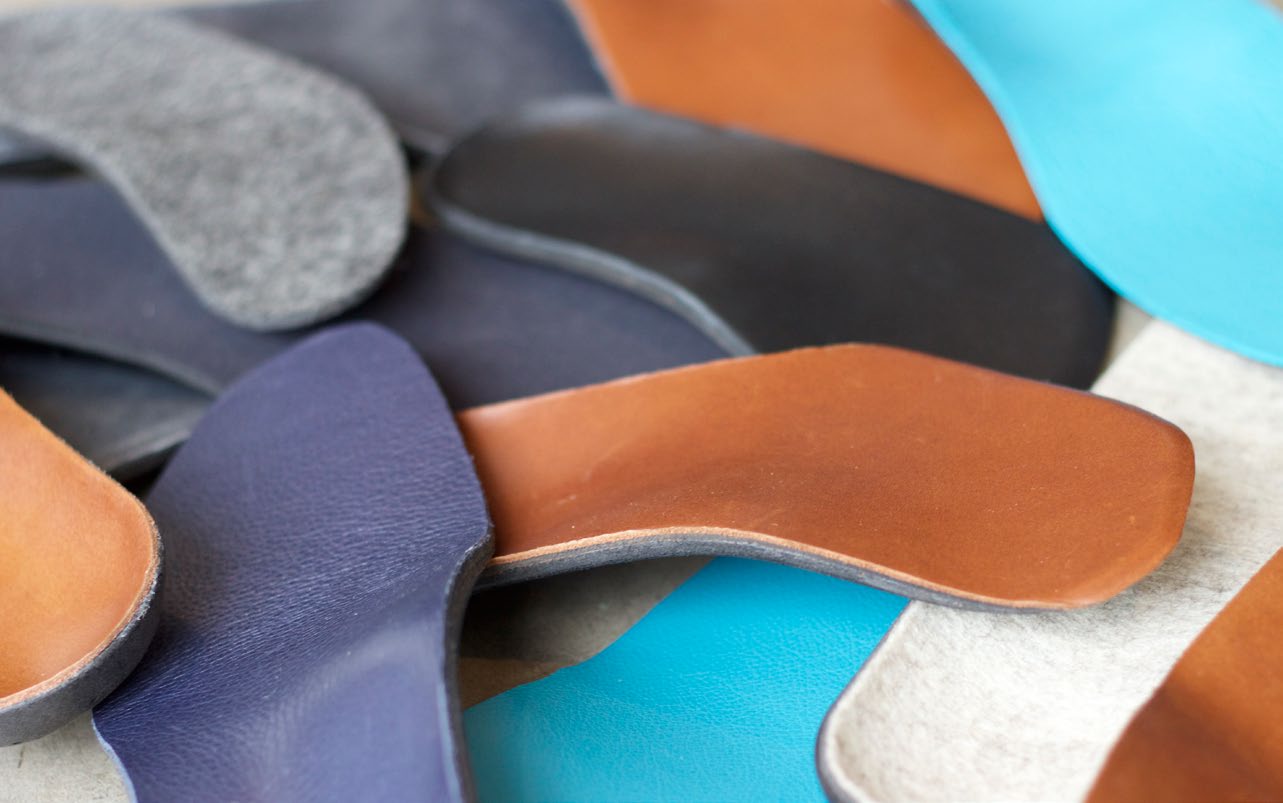 Traditional orthotic insoles in various materials — leather, foam, fabric